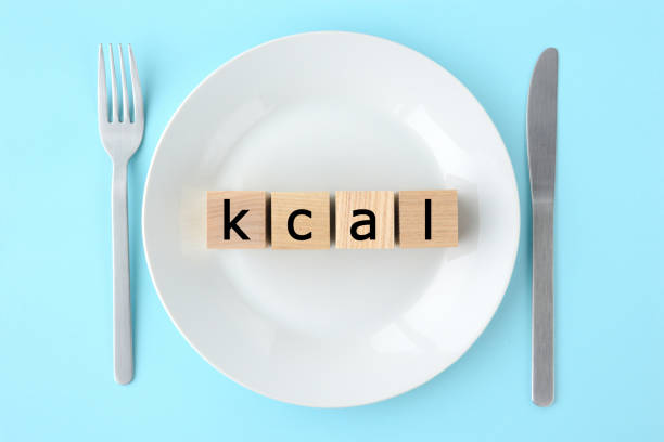 白いお皿の上に「Kcal」と書かれた積み木が置いてあり、両脇にナイフとフォークが置いてある画像。