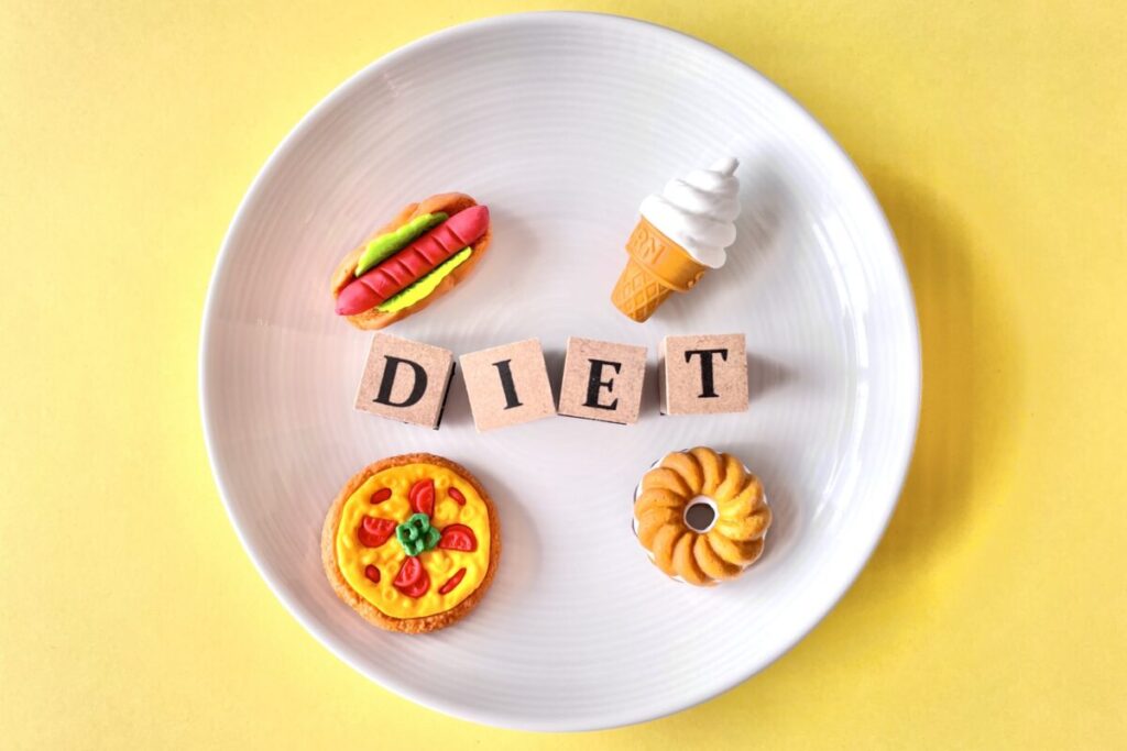 「DIET」と書かれているブロックと食べ物が載ったお皿の画像