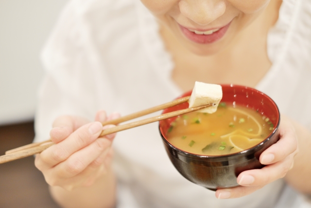 味噌汁を食べる女性の画像