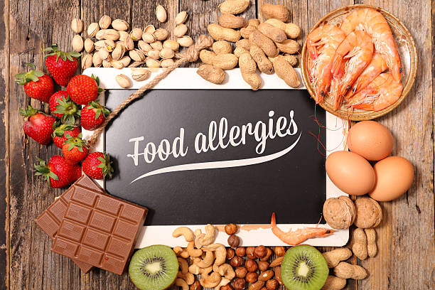 「food allergies」と書かれたボードの周りに、チョコレートなどアレルゲンになるいろいろな食材が置かれている画像