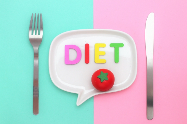 お皿の上に「DIET」の文字が書かれていて、お皿の両サイドにナイフとフォークが置かれた画像