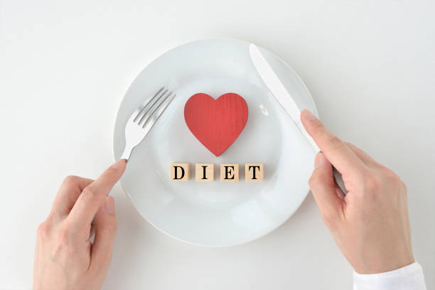 白いお皿にハートとDIETのブロックがあり、フォークとナイフを持っている手がある画像
