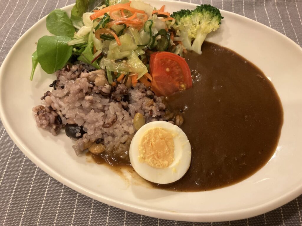 マイサイズのカレーにサラダとゆで卵をトッピングした画像。